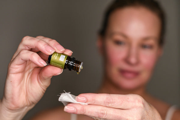 Woman applying aroma peel to cotton pad before applying to the face