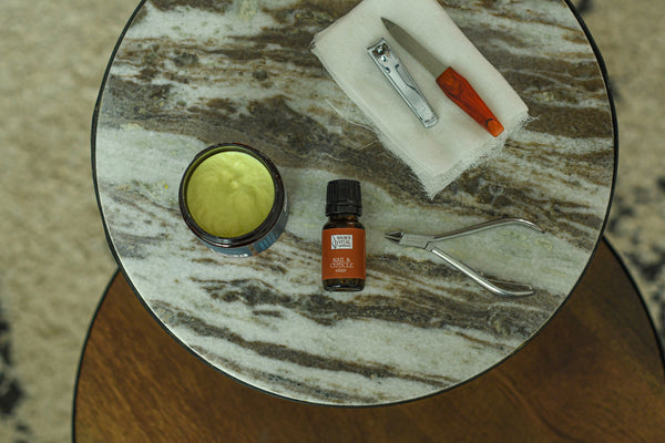 Marble table with nail tools and nail and cuticle elixir and lemongrass mani pedi cream