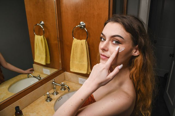 Woman at the sink applying face cream