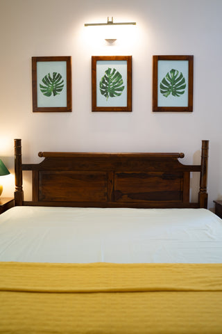 Headboard of solid wood bed, 3 paintings on the wall