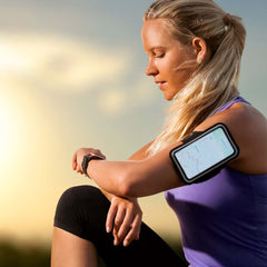 Portrait of a young woman taking a break during her run and checking her smart watch.