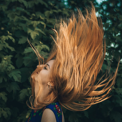 A woman flinging her hair into the air.