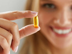 woman holding vitamin supplement capsule