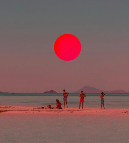 People on the beach and red sun