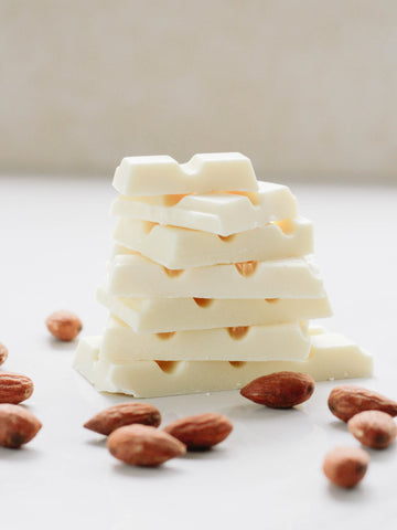 A pile of white chocolate surrounded by nuts