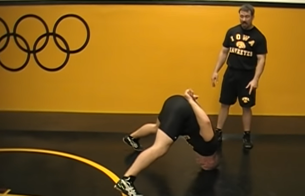 Collegiate wrestler from University of Iowa doing a front neck bridge