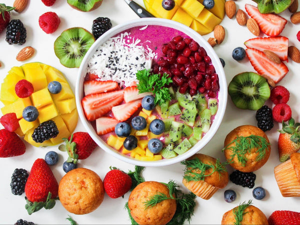 An acai bowl with fruit around the bowl