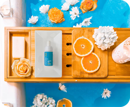 Wonderfeel Evening CBD on tray sitting on bathtub filled with fragrant flowers and orange slices. Photo by Heidi Kaden on Unsplash