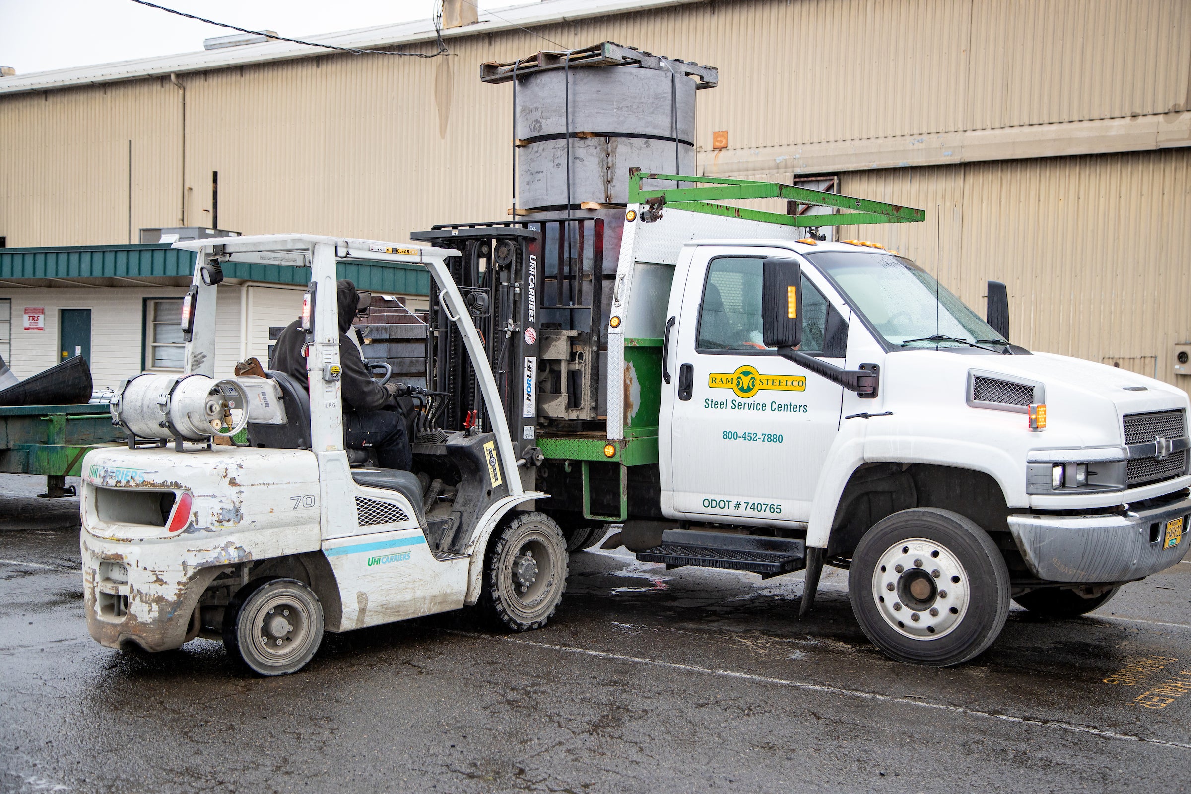 Delivery truck being loaded with steel and metal by forklift