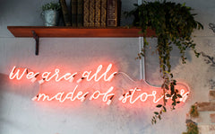 Neon sign: we are all made of stories