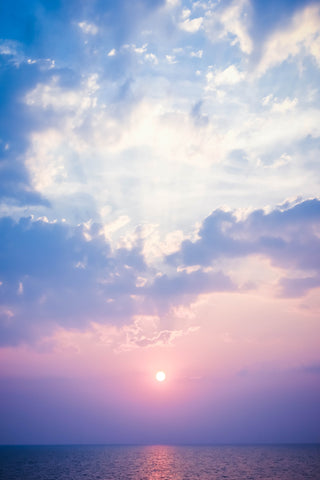 Prachtige lucht met roze, blauw, mooie wolken en een ondergaande zon.