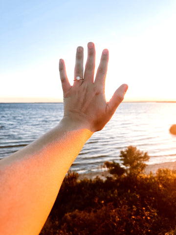 Woman Holds up her Hand with an Engagement Ring 