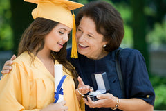 Mother gifts daughter a jewelry gift at her graduation
