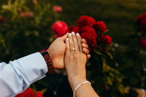 Man and Woman Hold Hands Showing off Engagement Ring