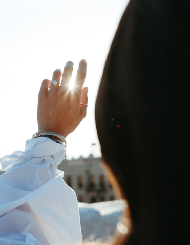 Engaged Woman Holding Up Hand with Ring in Front of the Sun