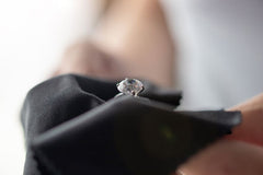 Person cleans diamond ring with cloth