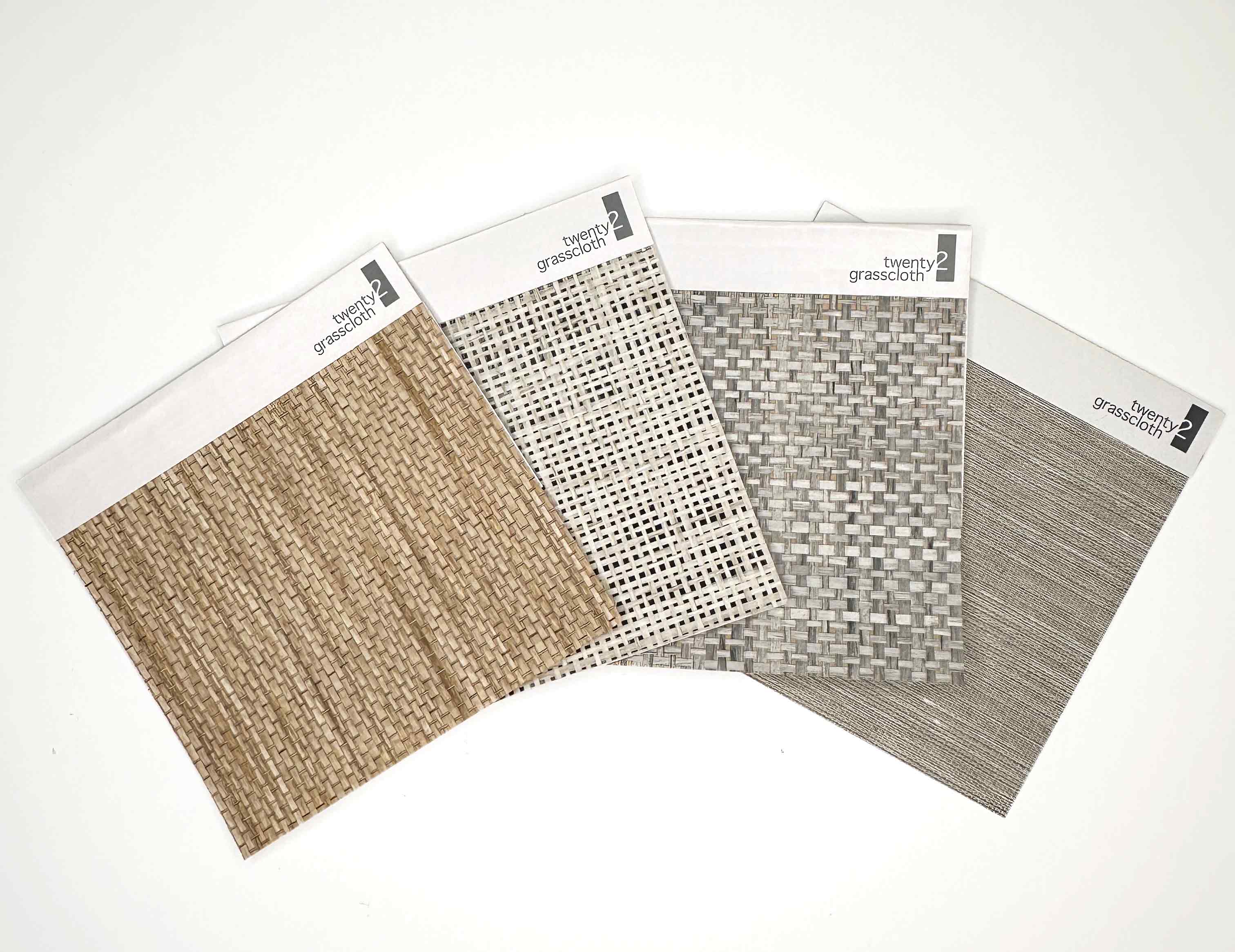 Four fanned out natural wallcovering grasscloth sample memos in neutral tones