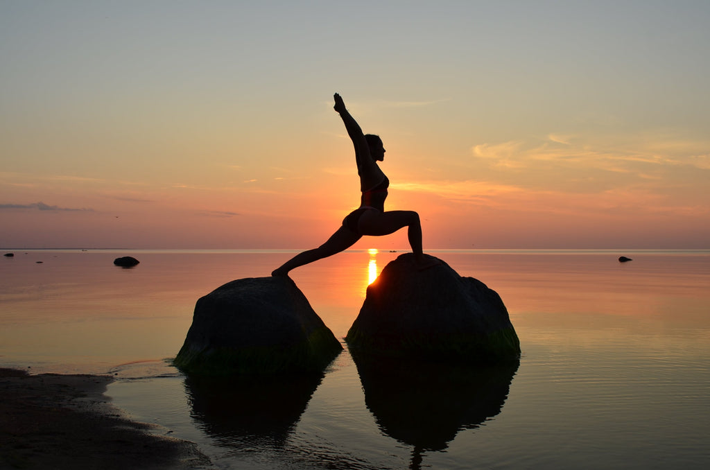 woman-on-beach-doing-yoga-nude-on-rocks-at-sunset