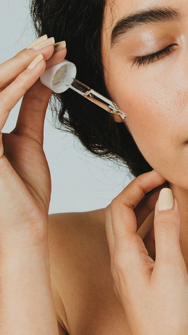 Woman applying a serum to her skin