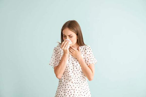 Allergies et symptômes grippaux - Femme se mouchant le nez