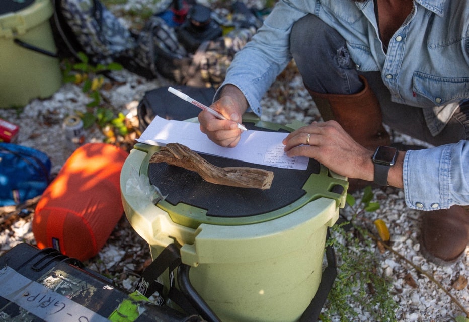 man writing on top of KULA 5 cooler