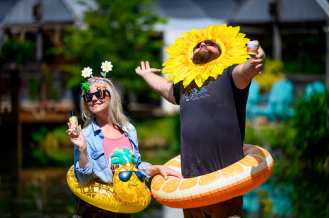 Amy and Jesse, owners of Appalachian Standard standing with pool floats on holding body care products