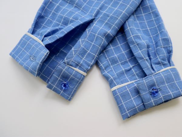 white piping sewn on blue cuffs