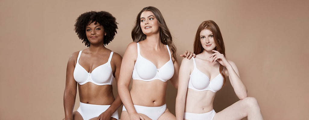 Three women wearing the white Corin Virginia t-shirt bra