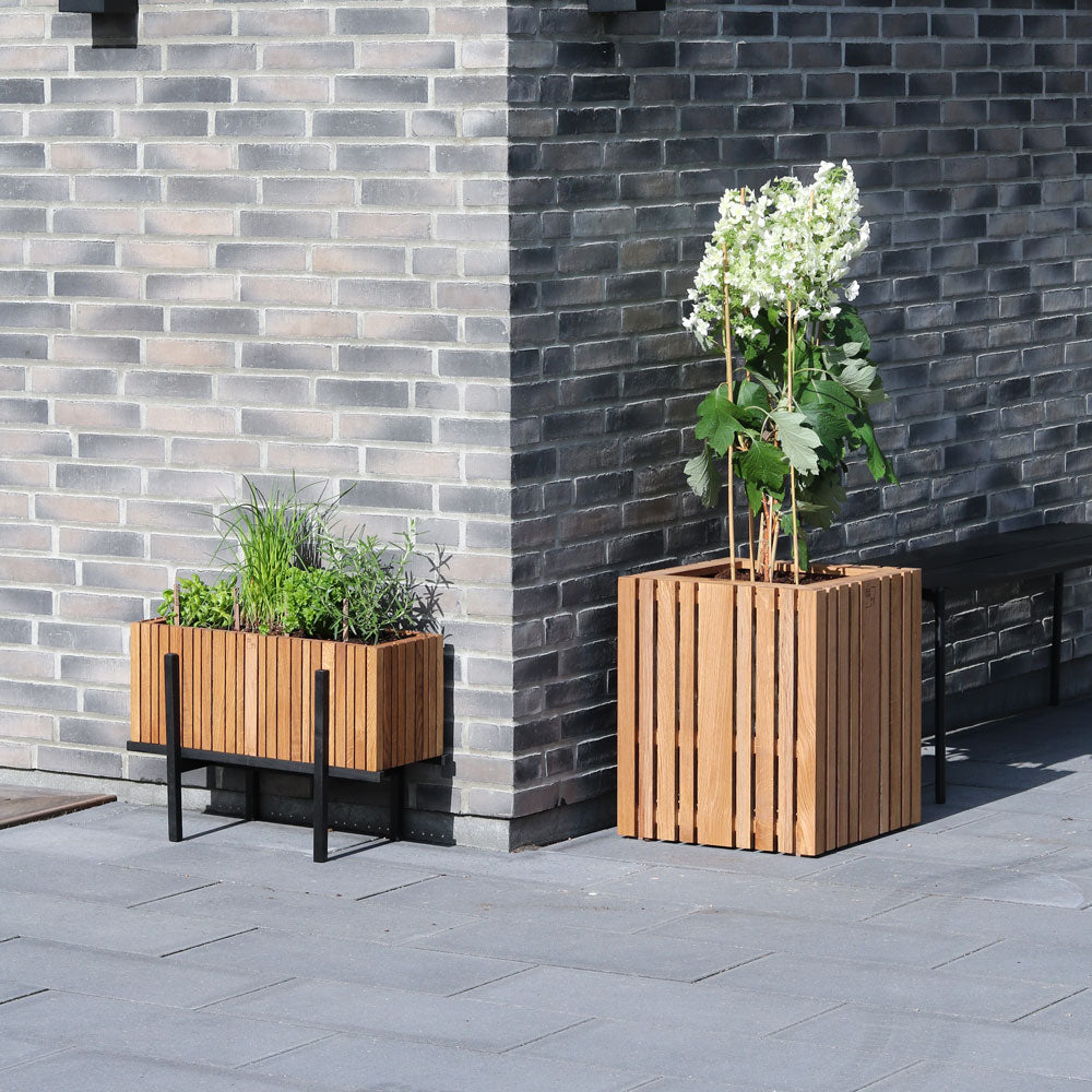 Wooden planters create a warm contrast to grey brick walls