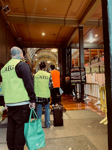 People in high-vis vests lining up to collect their exhibitor badges