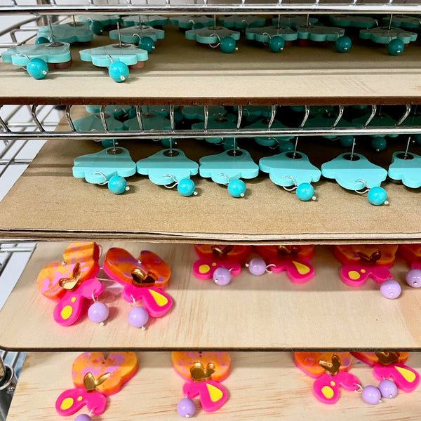 trays of earrings on a metal shelf