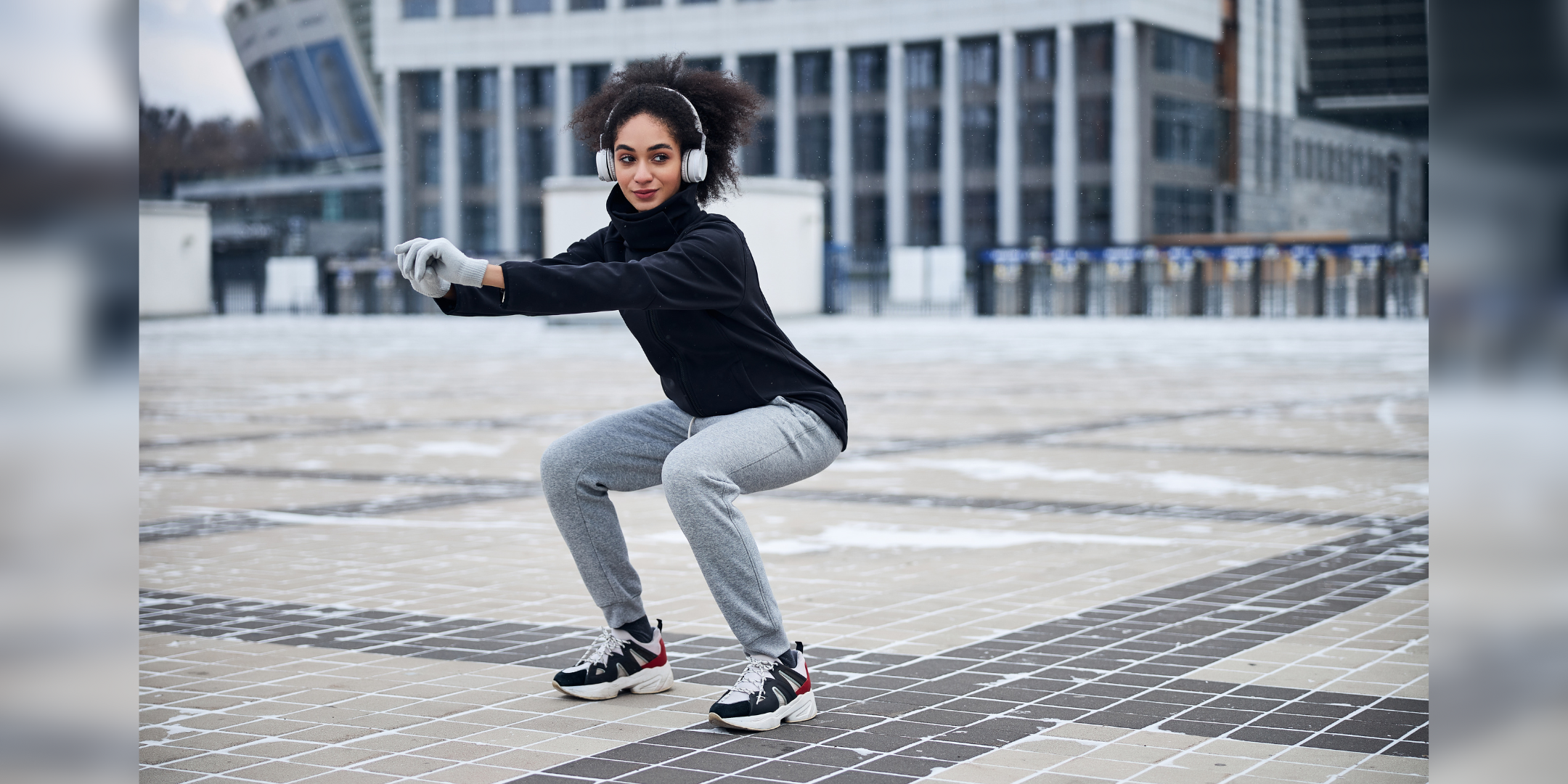 TANITA - Sportive person extending her arms before her and squatting while looking aside in headphones