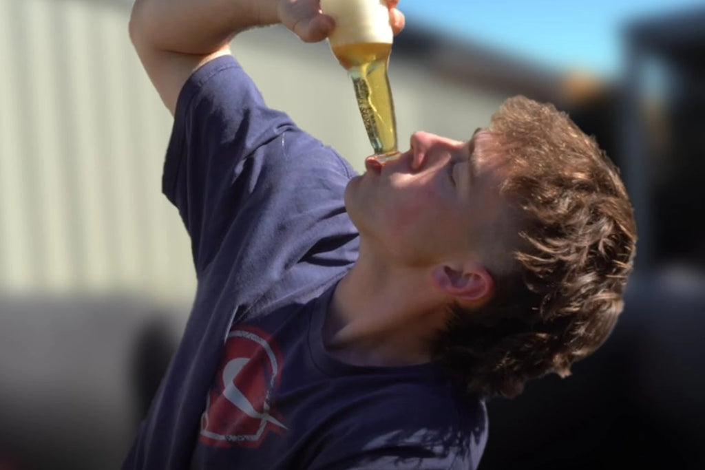 Junger Mann trinkt ein Bier auf ex