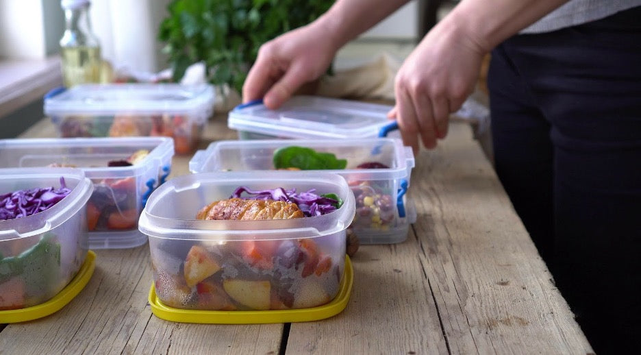 A person packaging their prepped meals.