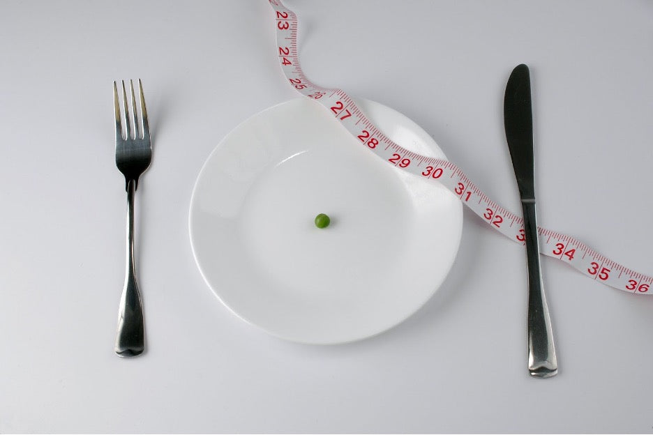 A plate with a single pea on it to represent a fab diet.