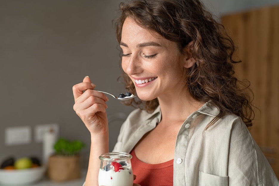 A person eating chia pudding and yogurt.