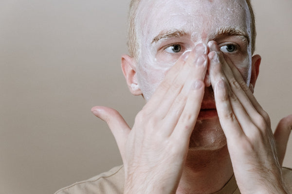 en man rengör ansiktet för att slippa vanliga misstag i hudvård för ansiktet