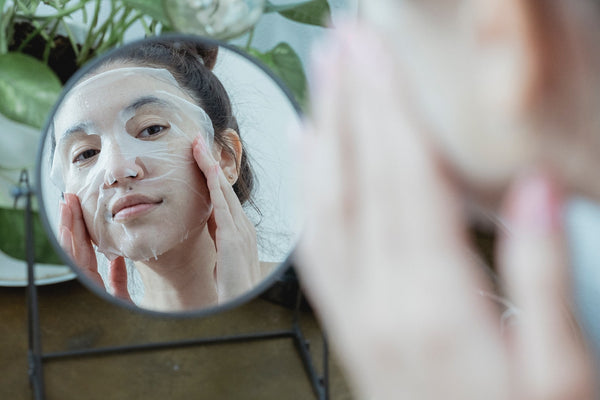en kvinna applicerar en ansiktsmask och njuter av en mysig höst