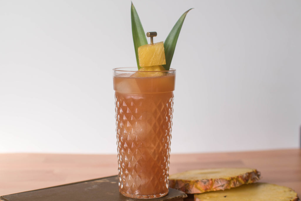 A tiki-like cocktail made with Iconic Mesquite Date, silver rum, and pineapple juice