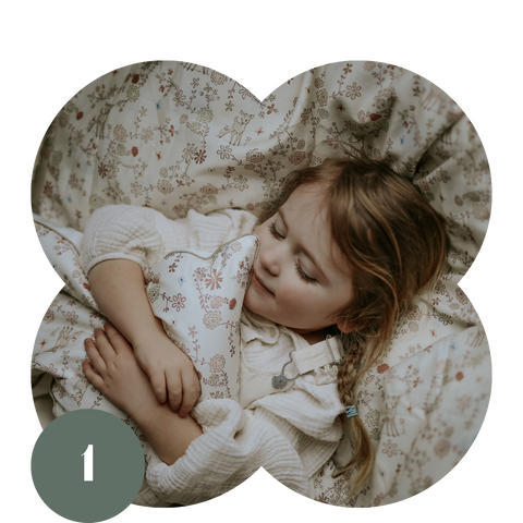 Toddler girl laying with garden printed pillow