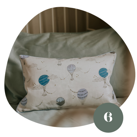 White pillow with a blue hot air balloons pattern