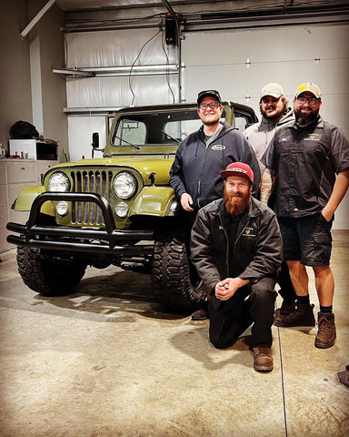 The team celebrates finishing the complete restoration of the vintage CJ8 Jeep Scrambler