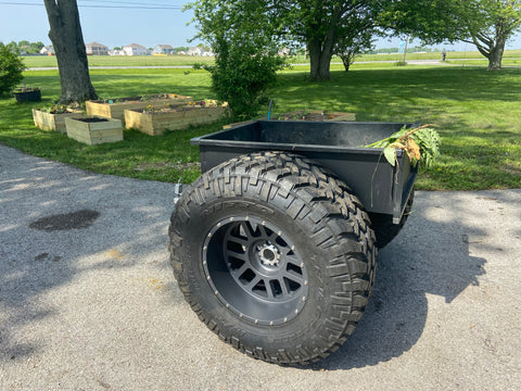 Giant mud tires are shown installed on a garden cart