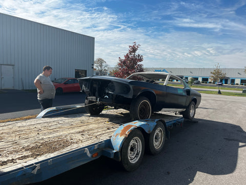 A mustang being rolled off of a trailer