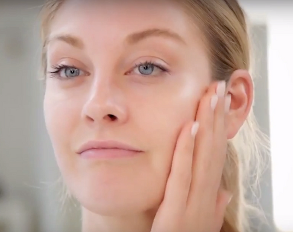 Frau streichelt ihr Gesicht nach die Ultraschall Gesichtsreinigung