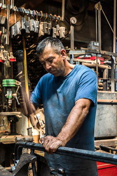 Pedro Cabos, a blacksmith at Christopher Thomson Ironworks, works at the anvil.