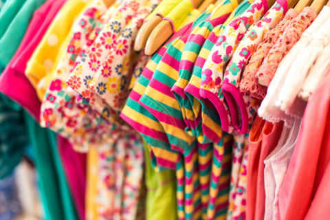 Row of brightly coloured children's clothes close up