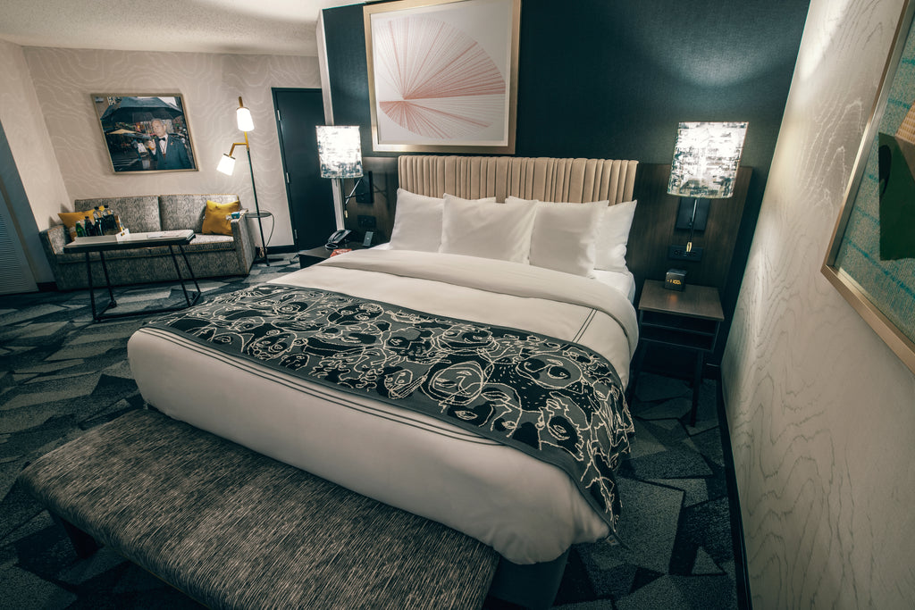 The interior of a guest room in the Saint Kate hotel, featuring a variety of artistic furniture and accents.