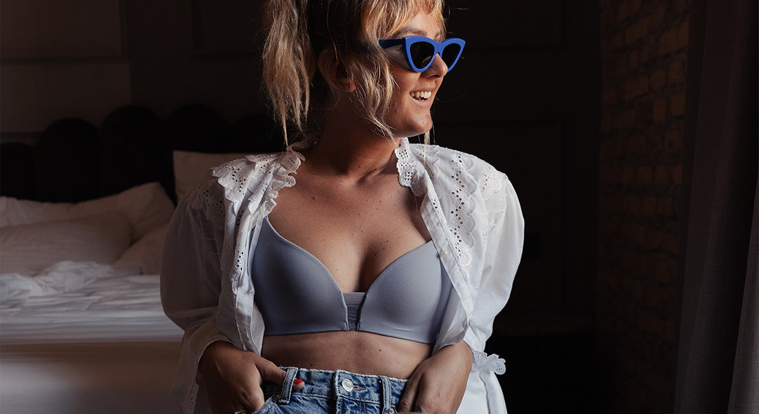 Our photographer Grace wears a grey Flex Smart bra with denim shorts and open white blouse, in Italy