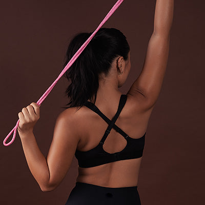 Women stretches triceps in Triaction Seamfree Crop